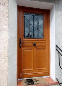 eine Holztür mit einem Fenster auf einem Gebäude in der Unterkunft Appartement L'oranger in Pégomas