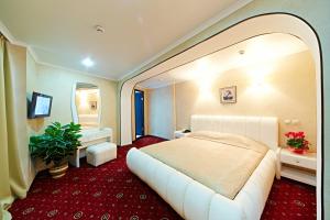 - une chambre avec un grand lit blanc et un miroir dans l'établissement Bryansk Hotel, à Briansk