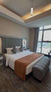 a bedroom with a large bed with a large window at Sunday Business Avenue Formerly Rand Hotel in Riyadh