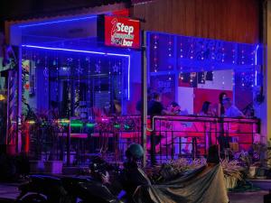 a group of people sitting at a bar with purple lights at New Nordic Suites 2 by Apartwell in Pattaya South