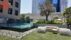 a swimming pool with two wicker chairs and a table at pearl 1bdr apartment in business bay in Dubai