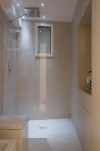 a white bathroom with a shower and a window at Solo per Noi Apartment in Siena