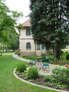 une maison avec une table et des chaises dans une cour dans l'établissement Pension Bier, à Burg