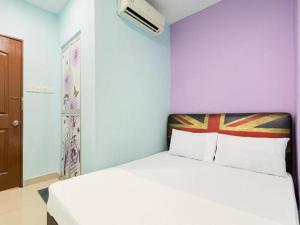 a bedroom with a white bed with purple walls at SPOT ON 89616 My Trillion Hotel in Kuala Lumpur