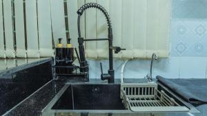 a kitchen with a sink with a faucet at Family Space in Dhaka +31 photos