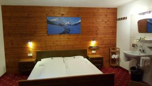 una camera da letto con un letto e un lavandino di Hotel Valisera a Galtür