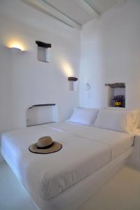 a hat sitting on a white bed in a room at Villa Aerino I & ΙΙ in Kámbos