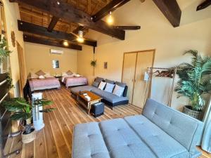 een grote woonkamer met een bank en een tafel bij RED ROOF ISHIGAKI in Ishigaki Island