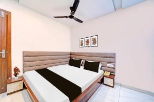 a bedroom with a bed and a ceiling fan at Super Townhouse LIG Main Road Indore in Indore +22 photos