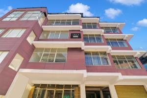 a tall building with lots of windows at Super Collection O Madikeri City Center Near KSRTC Bus Stand Coorg Formerly Hotel Ragsys in Madikeri