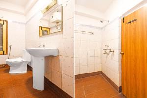 a bathroom with a toilet and a sink at Super Townhouse Hill Cart Road Siliguri in Siliguri