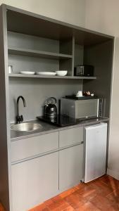 Modern Studio في كيب تاون: مطبخ مع حوض وميكروويف +صورتان