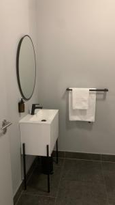 Modern Studio في كيب تاون: حمام مع حوض ومرآة ومناشف