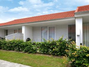 a white house with a red roof and some bushes at 4 person holiday home in Ærøskøbing in Ærøskøbing