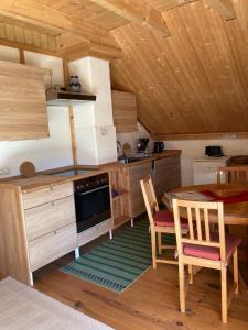 eine Küche mit Tisch und Stühlen in einer Hütte in der Unterkunft Öko Ferienwohnung HolzLehmSonne in Schwarzenbach an der Saale