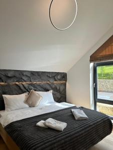 a bedroom with a large bed with two towels on it at Altfel Bran Chalet 1 in Bran