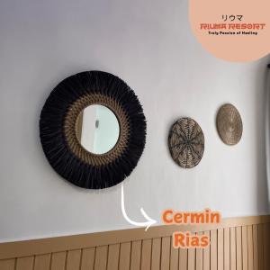 a mirror on a wall with some objects on it at Riuma Resort in Karangploso