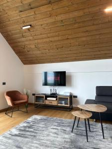 Una sala de estar con televisión, sofá y sillas. en Altfel Bran Chalet 1, en Bran
