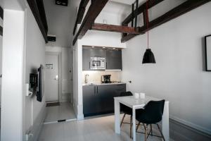 a small kitchen with a white table and chairs at Guldgränd in Stockholm