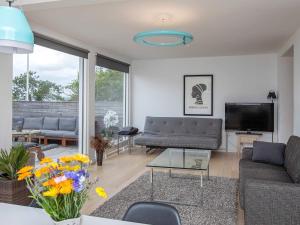 a living room with a couch and a tv at 8 person holiday home in Præstø in Præstø +20 photos