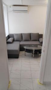 a living room with a couch and a glass table at Stan dve sobe, kupatilo, hodnik, kuninja, klima, masina za ves, parking, strogi centar in Negotin