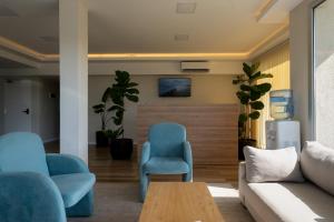 a living room with a couch and a chair at Terrazas Ostende - Apart Hotel in Ostende