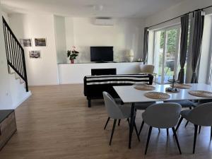 a living room with a table and a piano at Mirror Hill Lodge in Törökbálint +4 photos