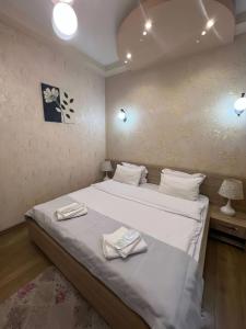 a bedroom with a bed with two towels on it at Sanapiro + in Tbilisi City
