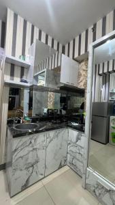 a kitchen with marble counter tops and a sink at Apartemen Anderson 28 1 Pakuwon mall Luxury Studio Apartment Connecting Mall, Pool & City View in Surabaya