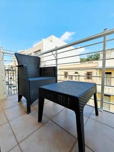 ein schwarzer Stuhl und ein Tisch auf einem Balkon in der Unterkunft Corner view 3 in Marsaskala + 7 Fotos