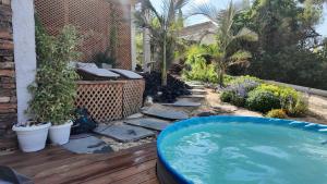 a backyard with a hot tub and a garden at צלילי המעיין- צימר בוטיק במדבר in Arad