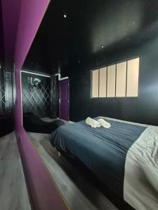 a bedroom with a bed with two white towels on it at Appartement Spa - Jacuzzi privatif - Fer Rêver 63 in Thiers