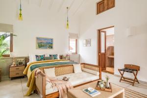 ein Schlafzimmer mit einem Bett, einer Couch und einem Tisch in der Unterkunft La Selva - 4BHK Luxury Villa in Assagao with Private Pool near Cafés & Soro Pub in Assagao