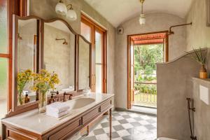 ein Badezimmer mit Waschbecken und großem Spiegel in der Unterkunft La Selva - 4BHK Luxury Villa in Assagao with Private Pool near Cafés & Soro Pub in Assagao