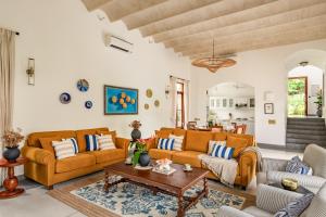 ein Wohnzimmer mit zwei Sofas und einem Tisch in der Unterkunft La Selva - 4BHK Luxury Villa in Assagao with Private Pool near Cafés & Soro Pub in Assagao