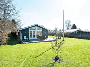 a small house in a yard with a tree at Cozy Retreat in Kysing Naes - By Traum Ferienwohnungen in Norsminde