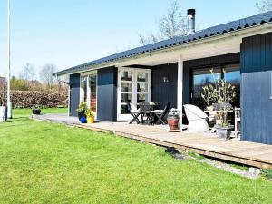 a house with a wooden deck in the yard at Cozy Retreat in Kysing Naes - By Traum Ferienwohnungen in Norsminde