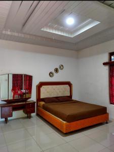 a bedroom with a bed and a dresser and a mirror at Sarah's Cottage Toba Samosir in Ambarita