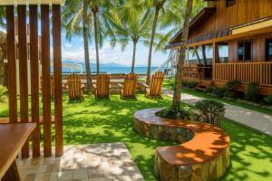 a patio with chairs and the ocean in the background at J's PALM BEACH Resort in Batangas City