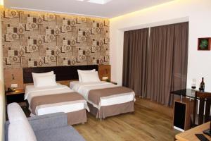 a hotel room with two beds and a couch at Hotel Panorama Gareji in Sagarejo