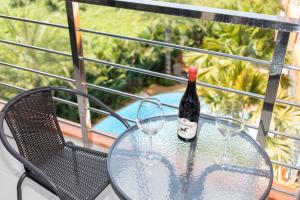 a bottle of wine sitting on a table with two glasses at MIRA Condo 1BR Pool View NBC Nai Harn in Nai Harn Beach