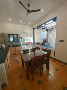cocina con mesa y sillas y ventilador de techo en NanDha Thotram-The Central Courtyard Heritage HomeStay Yelagiri Hills, en Yelagiri