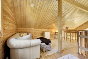 una stanza con un divano bianco in un soffitto di legno di Villa Nova a Pyhätunturi