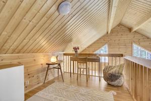 Camera con soffitto in legno, tavolo e sedia. di Villa Nova a Pyhätunturi