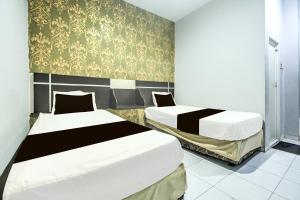 Ένα ή περισσότερα κρεβάτια σε δωμάτιο στο Hotel O Makassar near Mall Panakukang formerly Hotel Lucky Inn Makassar +26 φωτογραφίες