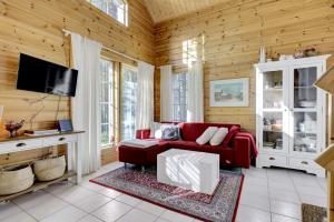 un soggiorno con un divano rosso e una TV di Villa Nova a Pyhätunturi