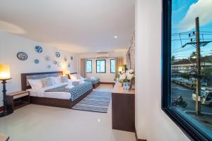 a living room with a bed and a window at Nyonya Maison Boutique Hotel Phuket Old Town in Phuket Town