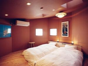 two beds in a room with red walls at 地元酒屋が手がける一棟貸し宿 -霧ノ音- in Kushiro +26 photos