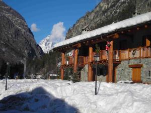 a building with a deck in the snow at A Cozy Alpine Retreat in Antey-Saint-André