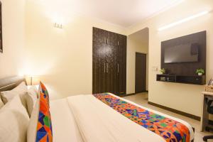 una habitación de hotel con una cama y un televisor en FabHotel Golf Luxury, en Gurgaon